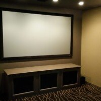 This quality ATMOS theater was built in a room that was previously used for storage. It features KEF speakers, an Epson Pro Series projector, SI screen, dual Sunfire subs. The cabinet was built by Fine Wood Creation.